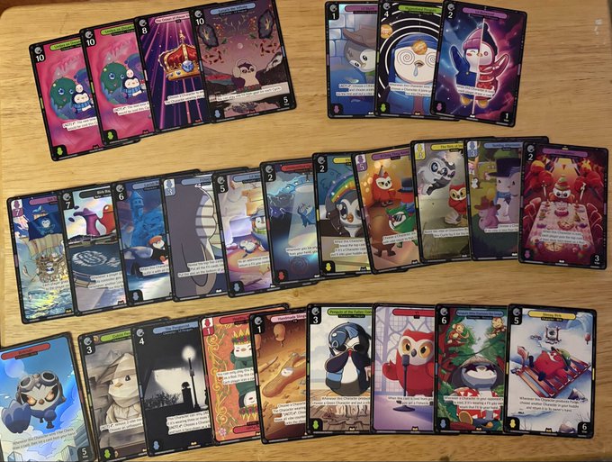 A collection of illustrated trading cards featuring various cartoon characters is spread out on a wooden table.