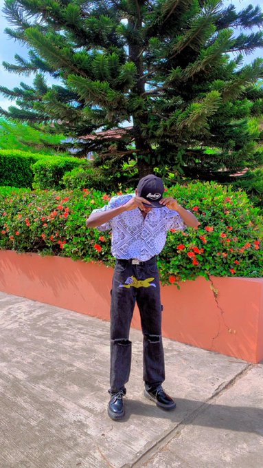 The image features a man standing next to a tree wearing a hat, with his hands on his head. The photo has been edited to include a caption that reads "happy friday frens lately i've been paying more attention to @injective it'S one of those chains built specifically for finance, making trading and DeFi faster and smoother without the usual headaches".