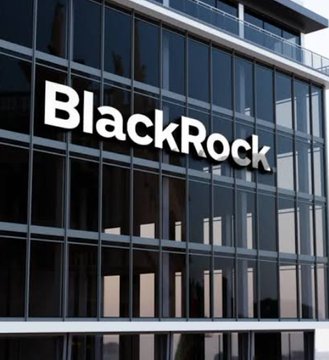 The image shows the exterior of a modern glass building displaying the "BlackRock" company name in large white letters on its facade. This directly relates to the accompanying text, which features a report from the financial giant BlackRock discussing Bitcoin's significant pullback while maintaining their long-term investment outlook.