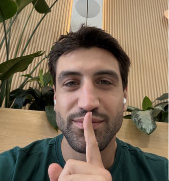 A man wearing earbuds holds his finger to his lips in a "shh" gesture, hinting at a surprise or upcoming announcement. The image pairs with the post inviting followers to meet him at Solana Summer House to connect IRL through Lolo.