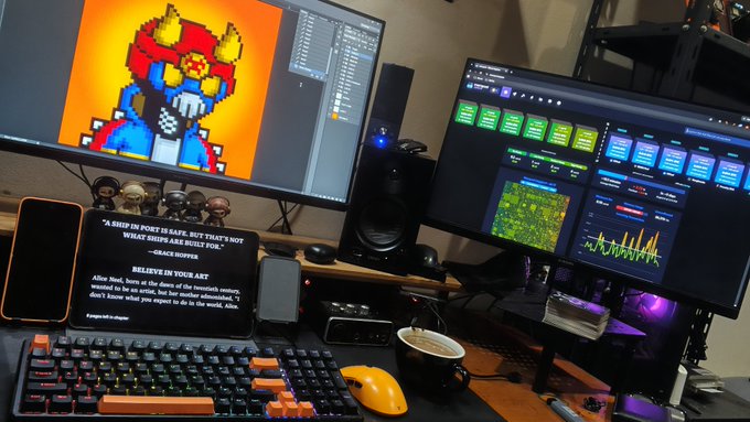 A computer desk setup features a main monitor displaying pixel art of a character holding flowers, a secondary screen showing audio software and a sports game, a mechanical keyboard, and a teleprompter displaying text from Sapolsky's 'Behave'.