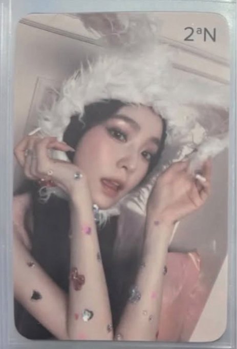A photocard labeled '2^N' showing a woman in a fluffy white hat with gemstone decals on her skin.