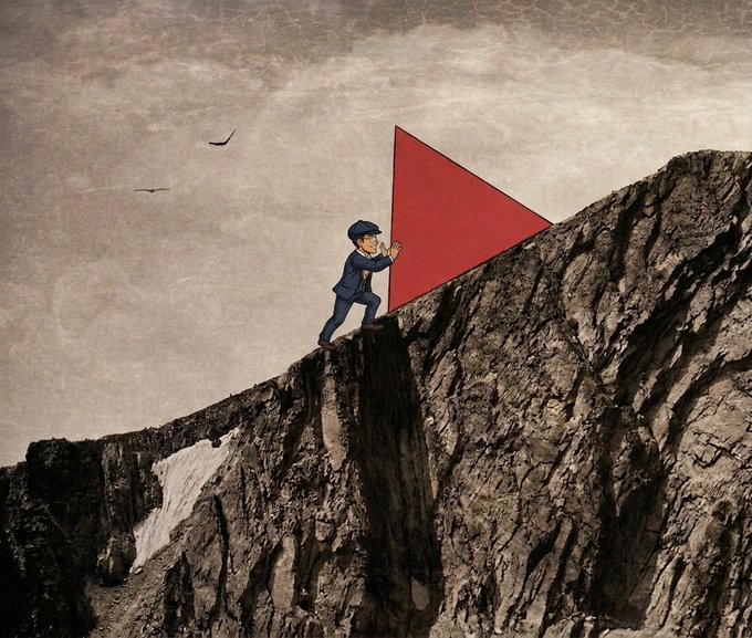 Surreal image of a person in a blue suit pushing a red play button triangle up a steep rocky cliff face, with birds flying in the sky.