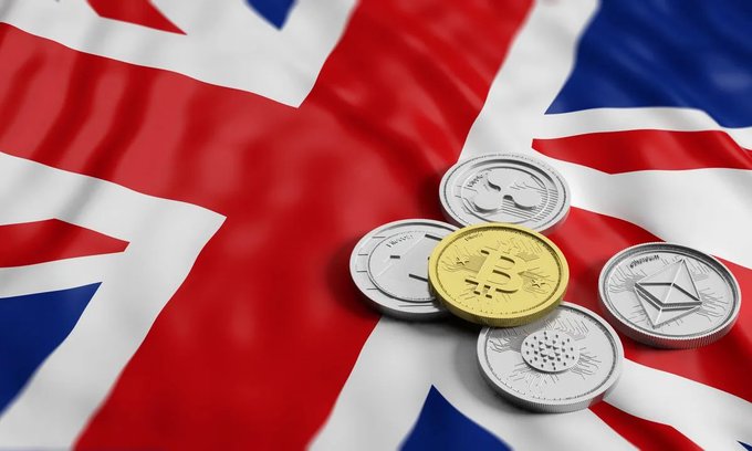 Physical representations of cryptocurrencies, including Bitcoin (₿), Ethereum (Ξ), Cardano, and XRP tokens, rest on a Union Jack flag, symbolizing the UK's growing acceptance and integration of digital assets into its financial system.