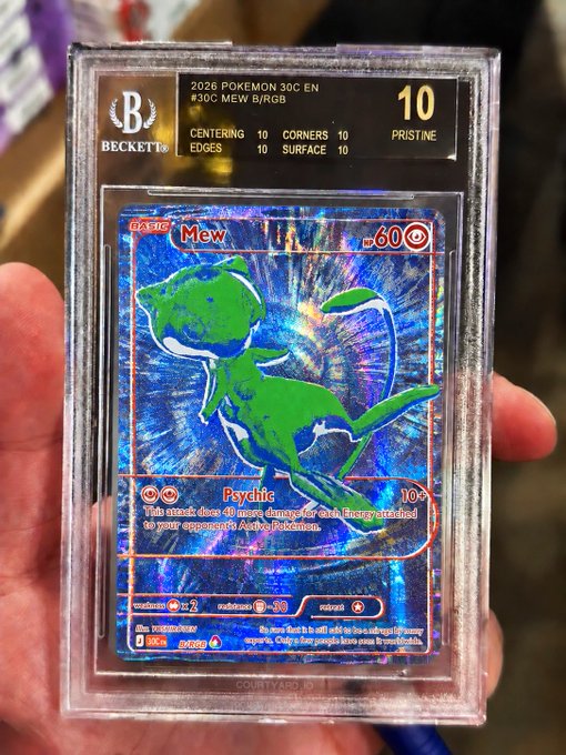 A hand proudly holds a Beckett-graded (BGS 10 Pristine) 2026 Pokémon 30th Anniversary Mew card (Pokémon #3, #30C) in a protective slab, with the caption "haters will say it's fake" serving as a playful flex of its perfect gem-mint condition.