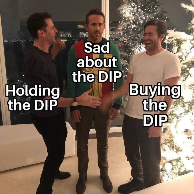 A meme image featuring actors Ben Affleck, Ryan Reynolds, and Hugh Jackman standing together; Affleck and Reynolds are labeled "Holding the DIP" and "Buying the DIP" while Jackman in the middle is labeled "Sad about the DIP," referencing crypto/stock market dips.