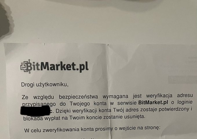 A printed letter in Polish from BitMarket.pl addressed to a user ('Drogi użytkowniku'), requesting verification of the address linked to their account, with sensitive information redacted.