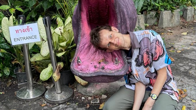 The image features a man posing with an elephant statue next to him while he lays down and looks at the camera. The elephant statue appears to have been crafted by a company named "ether". In the background of the photo, there are two signs indicating that this is a special event or exhibition for Ethereum, which seems to be related to cryptocurrency or digital assets like Bitcoin. However, there's no direct connection between the man and the elephant statue in the image, so it may not provide specific information about the price range during the months of March, April, May, June, July, or August.