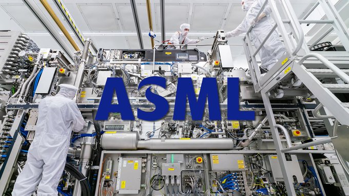 Workers in white cleanroom suits inspect large ASML semiconductor manufacturing equipment in a high-tech facility.