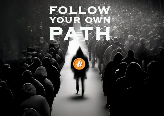 A black and white motivational graphic showing a hooded figure with a Bitcoin logo for a face walking through a crowd with the text 'FOLLOW YOUR OWN PATH'.