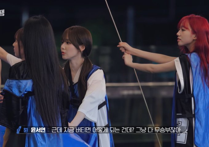 Three women in blue vests appear on a TV broadcast with Korean subtitles at the bottom featuring the name "윤서연" (Yoon Seoyeon) and the "S1" logo in the corner.