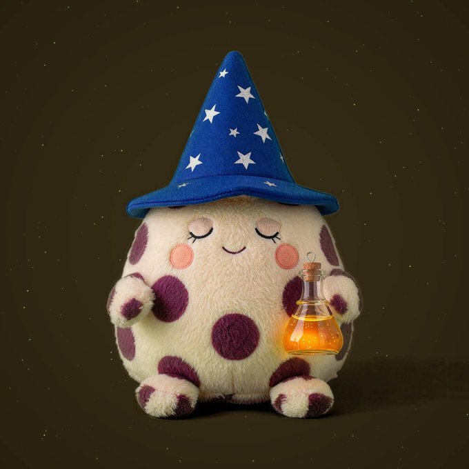 An adorable white plush toy with purple polka dots wearing a blue wizard hat covered in stars, peacefully holding a glowing bottle of yellow liquid against a dark background.