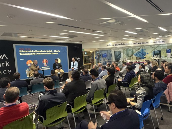 A panel discussion event at what appears to be a financial or capital markets venue, with four speakers on stage seated in front of a screen titled 'El Futuro de los Mercados de Capital' (The Future of Capital Markets), facing an audience of seated attendees.
