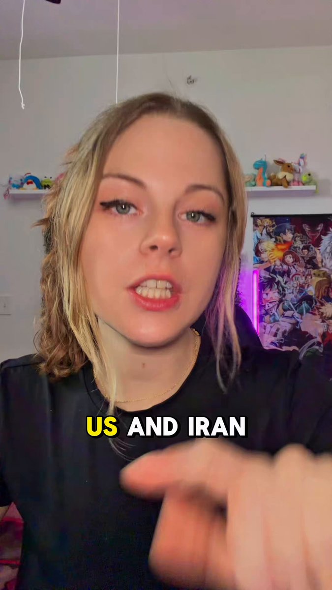 The image features a young blonde woman wearing a black shirt, with her hand extended towards the camera as if she's pointing or gesturing something out of frame. The background includes a white wall and a poster, suggesting that this photo was taken in an indoor setting like a living room or bedroom. The caption to the image reads "ON TODAYS BRAIN ROT NEWS", which implies that it is a recent news story or event.