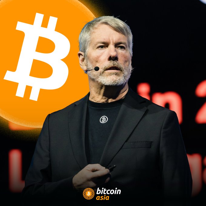 The image features a man wearing a suit standing next to an orange Bitcoin logo, with the text "Bitcoin Asia" written below him. The man appears to be giving a speech or presentation related to Bitcoin technology or cryptocurrency. The focus of the image is on the man and his surroundings, highlighting the importance of Bitcoin in today's world.