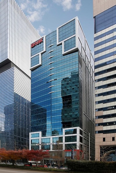 The image shows a modern glass office building with a "Bithumb" sign in red lettering at the top, identifying it as the headquarters of the South Korean cryptocurrency exchange. This relates to the post about the company's February error that mistakenly credited 620,000 BTC across hundreds of user accounts, leading to legal disputes now being addressed by a Seoul court.