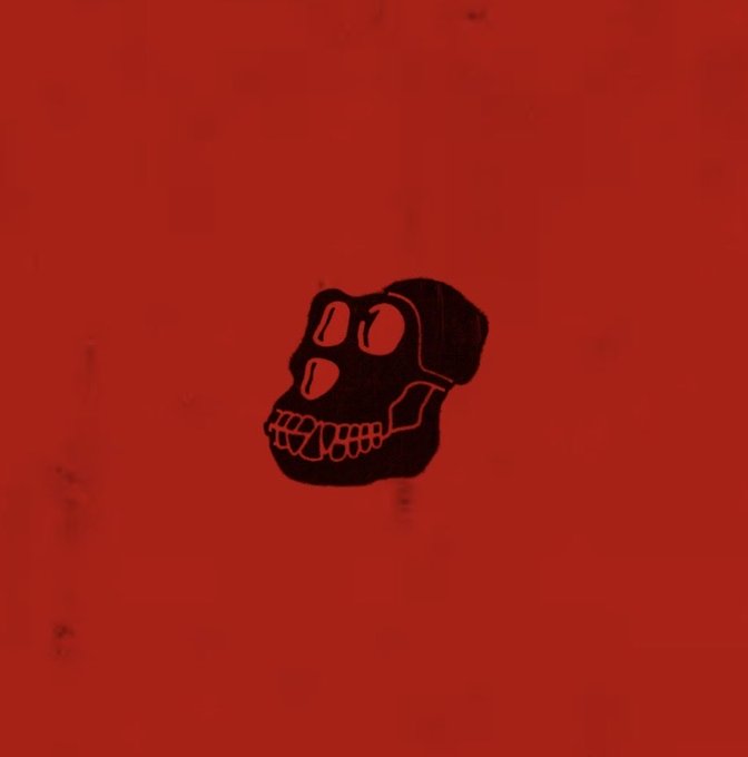 A minimalist illustration of a black skull-like character with large round eyes and an exaggerated toothy grin on a red background.
