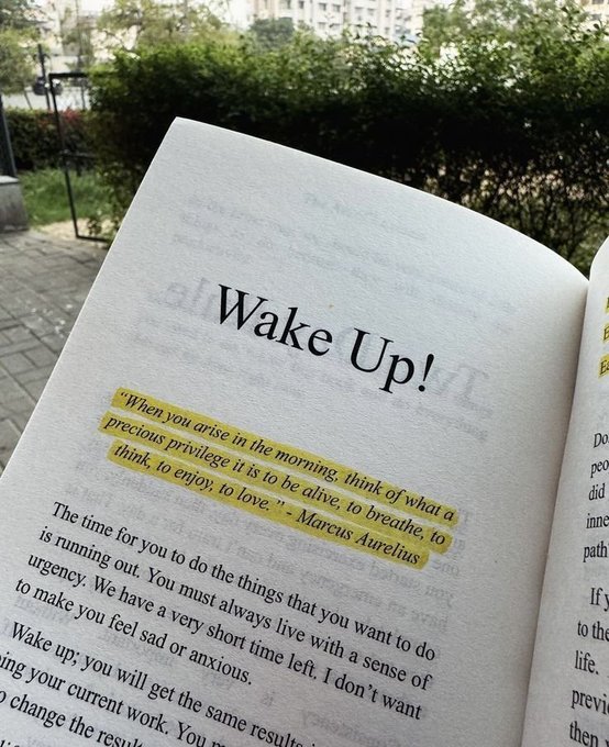 An open book page displays the heading "Wake Up!" with a highlighted Marcus Aurelius quote: "When you arise in the morning, think of what a precious privilege it is to be alive, to breathe, to think, to enjoy, to love."