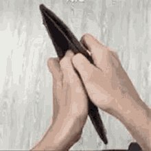The image shows a person's hands holding an open wallet, with their fingers spread out as if they are about to close it or count its contents. The background appears to be a white wall, which contrasts with the dark color of the wallet. The caption at the bottom of the image reads "Everyone scared about mythos launching in few hours Me rn:". This suggests that there might be an impending release or event related to Mythos, and people are concerned about its impact on their lives.