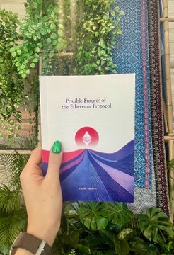 A hand holds a booklet titled 'Possible Future of the Ethereum Protocol' against a backdrop of plants and patterned fabric.