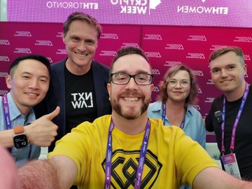 A selfie-style group photo at the Blockchain Futurist Conference featuring WEEX COO Andrew and KOL MartiniGuy (in a yellow "GMT" shirt) with three other attendees in front of a pink branded backdrop reading "BLOCKCHAIN FUTURIST CONFERENCE" (mirrored as seen in selfie mode). The image visually captures the post's highlight of WEEX leadership engaging with industry voices at the conference to discuss AI-driven autonomous trading.