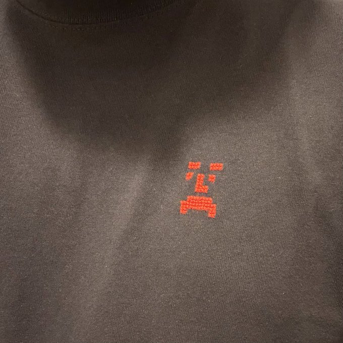 A black t-shirt features a small embroidered red "GORO" logo with a frowning face design on the chest, reflecting the post's promotional call to incorporate the GORO brand into everyday life.