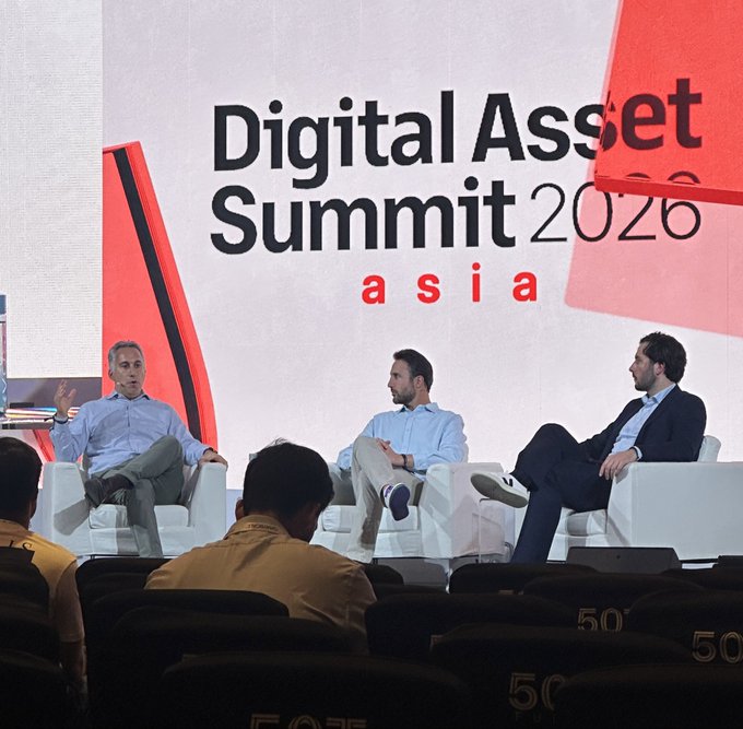 A panel discussion at the Digital Asset Summit 2026 Asia, showing three men seated on white chairs on a stage in front of an audience.