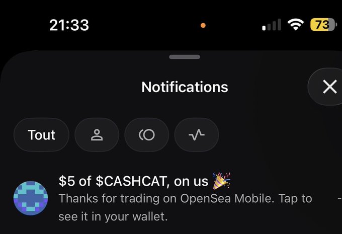 An iPhone notification from OpenSea Mobile at 21:33 announces a '$5 of $CASHCAT, on us 🎉' bonus for trading, showing a 73% battery level.