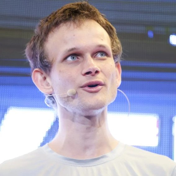 Vitalik Buterin, co-founder of Ethereum, is shown speaking at an event while wearing a headset microphone. The image accompanies news about his proposal to move heavy cryptography computations off-chain using STARKs, verified through EIP-8288, to reduce blockchain data demands.