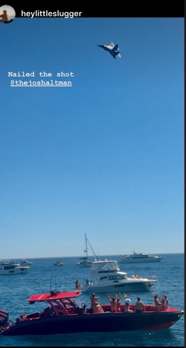 An Instagram story screenshot by 'heylittleslugger' captioned 'Nailed the shot @thejoshaltman', showing a blue fighter jet flying over boats on the ocean.