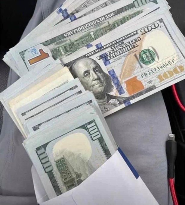 The image shows several U.S. $100 bills fanned out, with visible text including "UNITED STATES OF AMERICA," "ONE HUNDRED DOLLARS," "FEDERAL RESERVE NOTE," and a serial number "PB 11739845 F," with Benjamin Franklin's portrait prominently displayed.

The post's claim that the "first 600 people to like this post will receive money" is a classic engagement-bait scam, and the image of cash is used to lure people into interacting with it—no actual money will be sent, and the tactic is typically used to inflate the post's reach or harvest personal data.