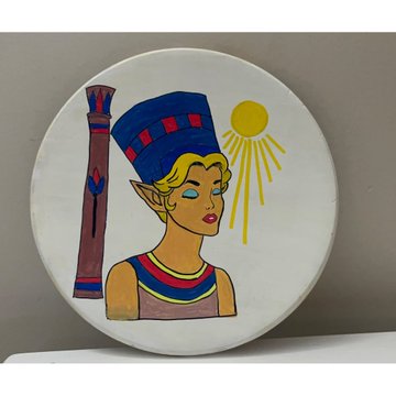 Decorative ceramic plate featuring an Egyptian-style female figure wearing a blue and red headdress, with a sun motif and a pillar design, displayed against a gray background.