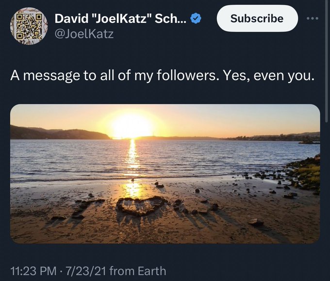 A Twitter post from David "JoelKatz" Sch... (@JoelKatz) reads 'A message to all of my followers. Yes, even you.' above a sunset beach photo with a heart drawn in the sand, posted 11:23 PM on 7/23/21.