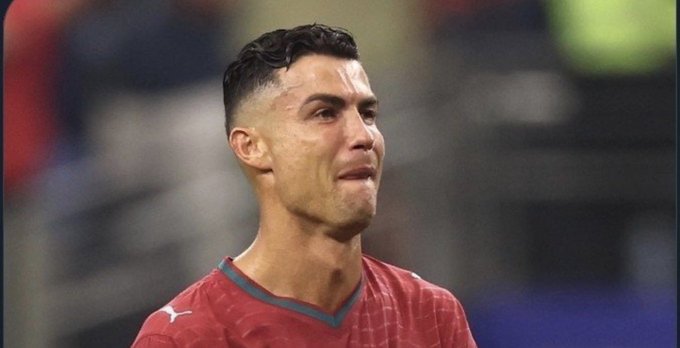 A close-up photograph of soccer player Cristiano Ronaldo in a red Puma jersey, appearing emotional with tears in his eyes during a match.