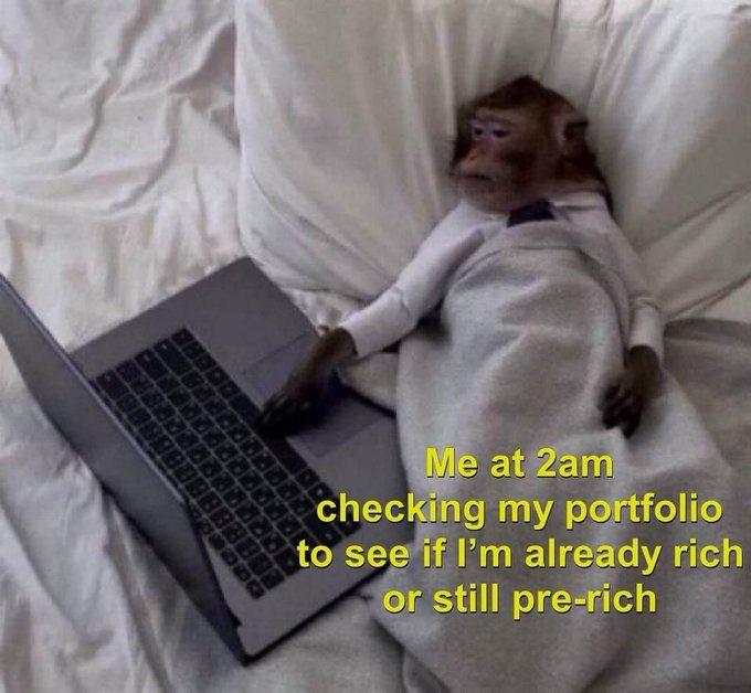 A monkey in pajamas lies in bed with a laptop, with yellow text reading "Me at 2am checking my portfolio to see if I'm already rich or still pre-rich," humorously capturing the relatable crypto trader's late-night ritual that pairs with a "GM GM" greeting.