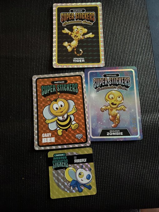 Four 'Super Stickers Protective Series' collectible cards featuring cartoon characters (Tremedous Tiger, Gary the Bee, Zealous Zombie, and Li Firefly) from VoxFriends are displayed on a textured black surface.