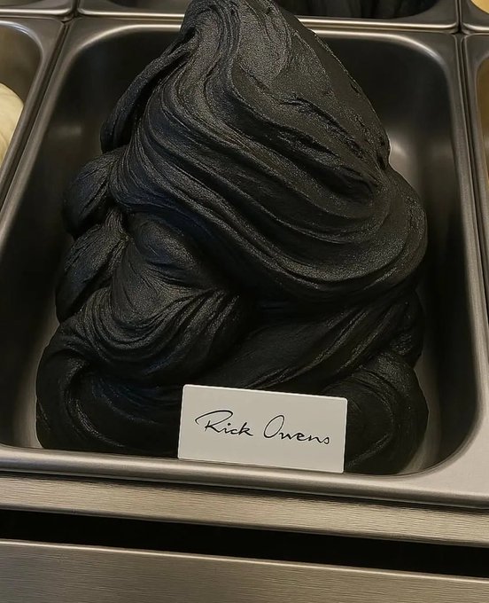 A container of black ice cream with a handwritten label reading 'Rick Owens' placed in front of it.