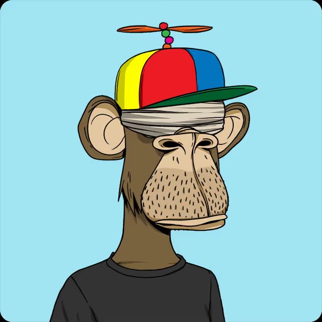 The image features an anthropomorphic monkey wearing a colorful hat with a propeller, standing against a blue background. The monkey appears to be posing for the photo, possibly as part of a social media post or promotional material. The caption below the image reads "I finally pulled the trigger on a longterm goal so stoked to bring home this ape and what it represents for the space @mfigge and @BoredApeYC".