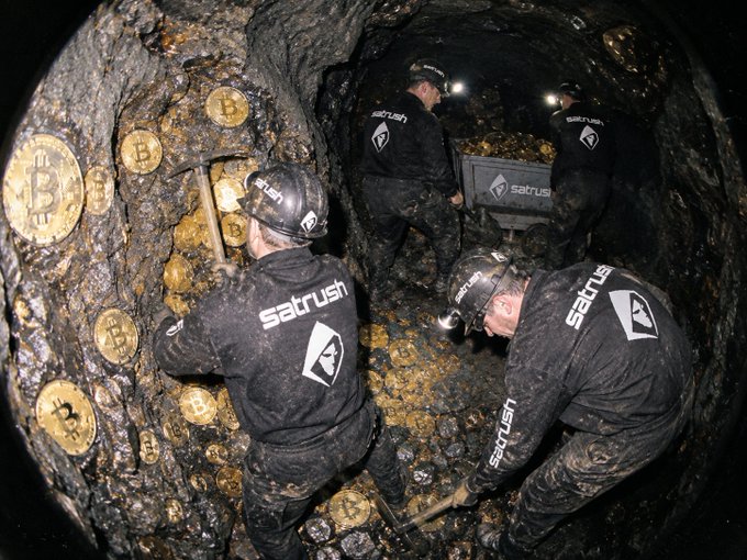 Miners wearing hard hats with headlamps work in a dark tunnel, using pickaxes to dig into a rock wall embedded with golden Bitcoin symbols, with a cart labeled 'satrush' visible.