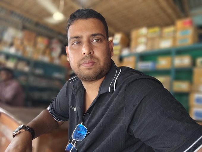 A man wearing a black shirt and sunglasses leaning against a wooden table, possibly waiting for something. The post is titled "Good morning my X family @perx_trade currently generates some of the highest activity across the nomisma ecosystem. Today busy day @NomismaNetwork Alpha @useTria". This image could be related to the post by showing an overview or visual summary of the photo in the context of the topic, which seems to be related to PerX and their activity.