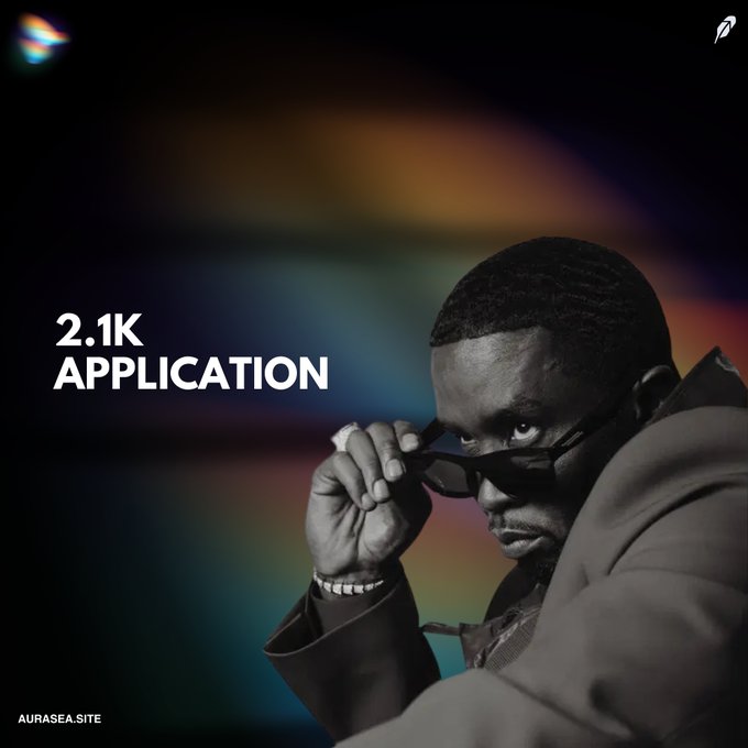 A promotional image showing a man in sunglasses and a leather jacket pulling down his shades, with text reading '2.1K APPLICATION' and 'AURASEA.SITE'.