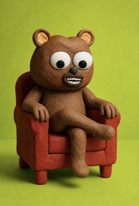 A 3D claymation-style brown bear character with a wide grin, sitting relaxed in a small red armchair against a green background.
