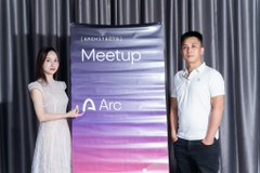 Two people stand on either side of a banner reading 'Meetup' with an 'Arc' logo, likely at a Cardano community event.