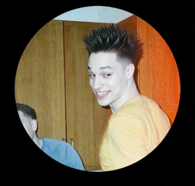 A young man with a spiky hairstyle smiles at the camera in a circular-framed photo, with a distinctive white face/powder appearance, fitting the giveaway post's theme of changing profile pictures to qualify for the 3.2m token reward.
