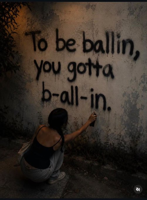 A person crouches to spray-paint the phrase "To be ballin, you gotta b-all-in." on a weathered wall, echoing the post's theme of going all-in ("$allinu") with full commitment in order to ball (achieve success, shown by "$ballinu").