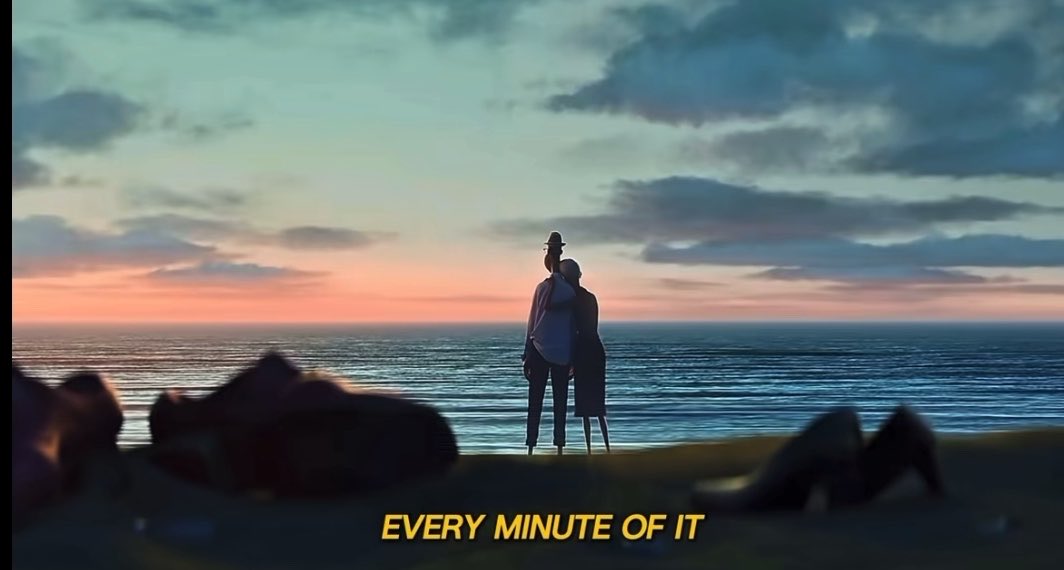 An animated scene of two figures watching a sunset over the ocean with the subtitle 'EVERY MINUTE OF IT'.