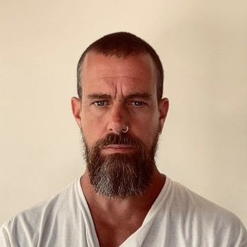 A bearded man with a nose ring wearing a white v-neck shirt stares intensely at the camera against a plain beige background. The image does not appear to relate to the post about Jack Dorsey's Block and its quarterly financial performance.