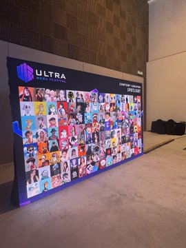 An event display wall labeled "ULTRA Worldwide" featuring a large collage of headshot photos of various people, set up in what appears to be a conference or event venue.