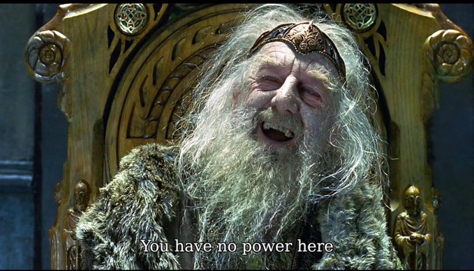 A movie still of an older bearded king wearing a crown and fur cloak on a throne, with the subtitle 'You have no power here' displayed at the bottom.