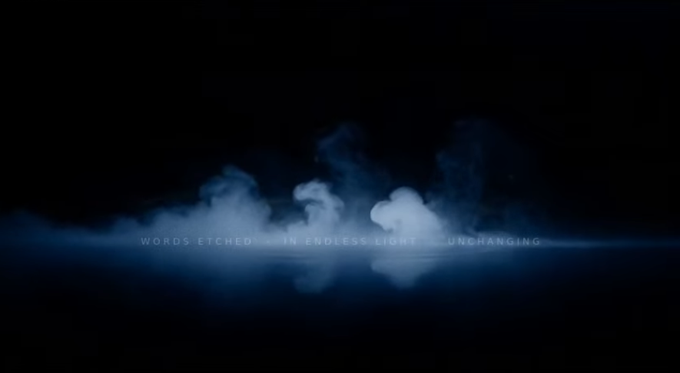 A dark, atmospheric image shows billowing blue-tinged smoke against a black background, with the text "WORDS ETCHED IN ENDLESS LIGHT UNCHANGING" glowing in a thin horizontal light beam across the center. The ethereal, misty visual mirrors the post's theme of prayers being transformed, vocalized, and permanently inscribed—evoking the luminous and lasting quality of words being "etched" and woven into the blockchain.